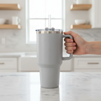 Toolbox Coffee 40 oz Light Grey Insulated Tumbler held in hand over marble countertop